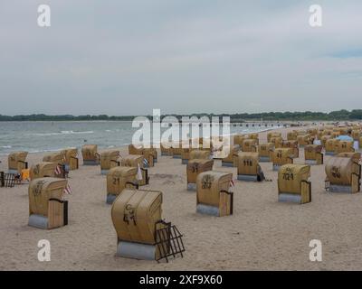 Viele Liegen entlang eines Sandstrandes unter bewölktem Himmel, lübeck, Ostsee, Deutschland Stockfoto