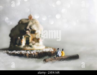 Miniaturmenschen Figuren vor einem Hausschmuck in verschneite Umgebung Stockfoto