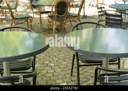 Leere Tische vor einem Café laden zum Sitzen ein, sich auszuruhen und einen Drink oder Essen zu sich zu nehmen. Niedrige Feldtiefe. Stockfoto