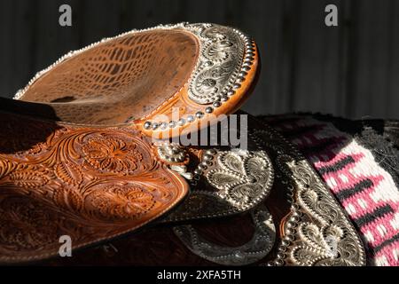 Detail mit graviertem Silberbesatz auf einem Ledersattel auf einer Rodeo-Spezialität, die andalusisches Pferd bei einem Rodeo in Utah spielt. Stockfoto