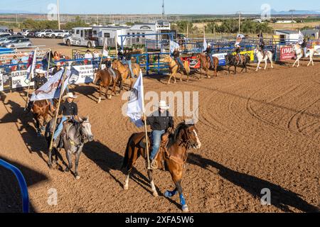 Junge Cowgirls und Cowboys tragen die Sponsorenflaggen im Grand Entry bei einem Rodeo in einer kleinen ländlichen Stadt Utahs. Stockfoto