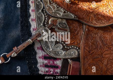 Detail mit graviertem Silberbesatz auf einem Ledersattel auf einer Rodeo-Spezialität, die andalusisches Pferd bei einem Rodeo in Utah spielt. Stockfoto