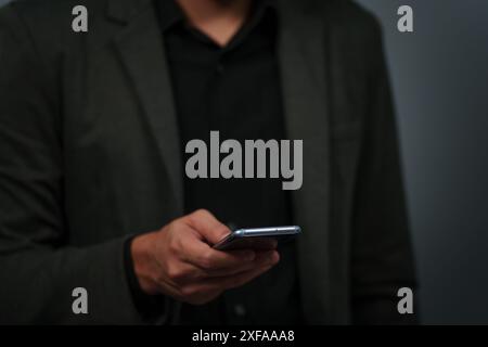 Hand eines Geschäftsmannes im Anzug mit Smartphone Stockfoto