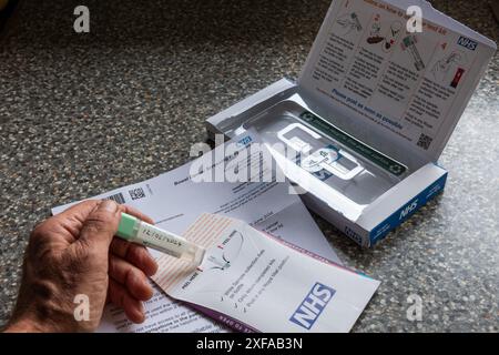Es ist zu wichtig, um einen Brief des NHS für die Erkennung von Darmkrebs mit einem Return-Home-Probenset zu ignorieren, und darüber mit einer Tasse nachzudenken Stockfoto