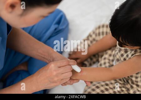 Mutter, die antiallergische Creme auf Allergie mit rotem Fleck am Babyarm nach rotem Mückenbiss aufträgt Stockfoto