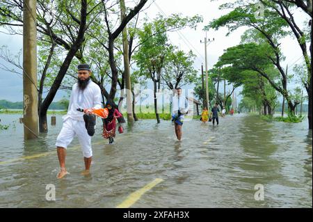 Die Menschen laufen durch das Hochwasser in der Gobindogonj - Chhatak Straße des Sunamgonj Bezirks der Sylhet Division. Bangladesch. Stockfoto