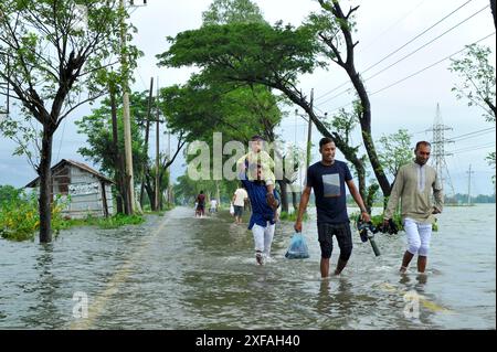 Die Menschen laufen durch das Hochwasser in der Gobindogonj - Chhatak Straße des Sunamgonj Bezirks der Sylhet Division. Bangladesch. Stockfoto