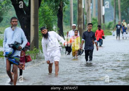 Die Menschen laufen durch das Hochwasser in der Gobindogonj - Chhatak Straße des Sunamgonj Bezirks der Sylhet Division. Bangladesch. Stockfoto