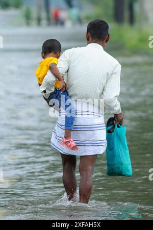 Die Menschen laufen durch das Hochwasser in der Gobindogonj - Chhatak Straße des Sunamgonj Bezirks der Sylhet Division. Bangladesch. Stockfoto