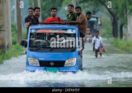 Die Menschen laufen durch das Hochwasser in der Gobindogonj - Chhatak Straße des Sunamgonj Bezirks der Sylhet Division. Bangladesch. Stockfoto