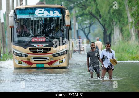 Die Menschen laufen durch das Hochwasser in der Gobindogonj - Chhatak Straße des Sunamgonj Bezirks der Sylhet Division. Bangladesch. Stockfoto