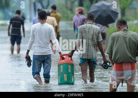 Die Menschen laufen durch das Hochwasser in der Gobindogonj - Chhatak Straße des Sunamgonj Bezirks der Sylhet Division. Bangladesch. Stockfoto