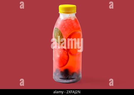 Limonade mit Johannisbeeren, Limette, Minze, Kaugummisirup, Eis, Soda-Wasser auf rotem Hintergrund für die Website zur Lebensmittellieferung Stockfoto