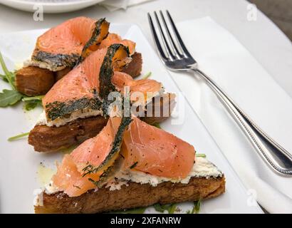 Kräuterlachslein auf Toast mit Frischkäse (Frühstück Gravlax offene Sandwiches) Rucola Zitronendrizzle (Dillkruste Fisch mit Kräutern) Toast Brot Stockfoto