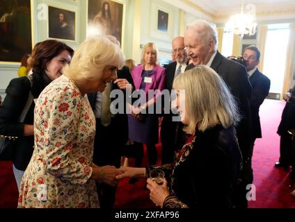 Königin Camilla (links) spricht mit Lady Elizabeth McCall Smith (rechts) und ihrem Ehemann Sir Alexander McCall Smith (hinten, rechts) bei einer Feier für diejenigen, die die schottische Alphabetisierung im Palace of Holyroodhouse in Edinburgh fördern, einschließlich Buchläden und Autoren. und Vertreter des Edinburgh International Book Festival und des Scottish Book Trust. Bilddatum: Dienstag, 2. Juli 2024. Stockfoto