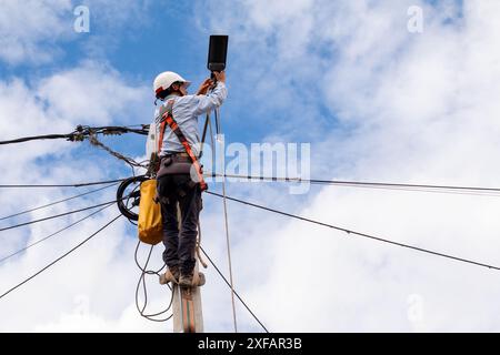 Elektrotechniker führt die Wartung der Straßenbeleuchtung an den Masten der Stadt durch Stockfoto