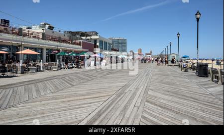 Asbury Park, NJ - 1. Juni 2024: Die Menschen gehen auf der Promenade neben dem Strand am Asbury Park New Jersey Ufer. Stockfoto