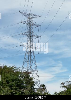 Hochspannungs-Pylonturm auf bewölktem blauem Himmel Hintergrund Stockfoto