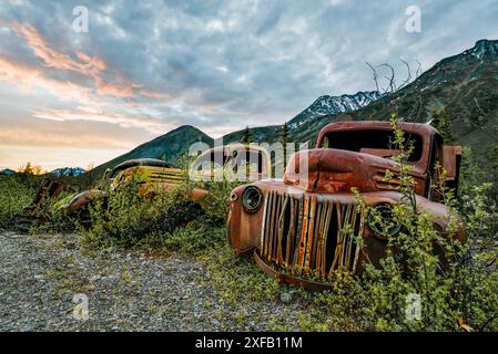 Ein alter, rostiger, alter Truck, eingebettet in die Wildnis mit Sommer-Berguntergang und Sonnenuntergang. Stockfoto