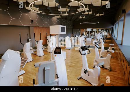 Hochwinkelaufnahme der Cardio-Zone im Premium-Fitness-Club, Zimmer mit weißen Crosstrainer und Heimtrainer Stockfoto