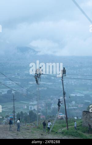 Bhaktapur, Bagmati, Nepal. Juli 2024. Arbeiter, die am Dienstag die elektrischen Leitungen von einem alten Versorgungsmast auf einen neuen in Nagarkot übertragen. (Kreditbild: © Amit Machamasi/ZUMA Press Wire) NUR REDAKTIONELLE VERWENDUNG! Nicht für kommerzielle ZWECKE! Stockfoto