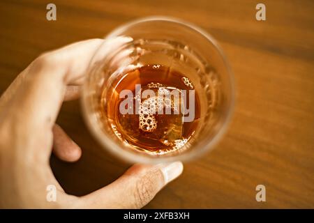 Jemand hält eine Tasse schwarzen Kaffee in der Hand Stockfoto