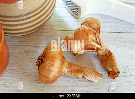 Eiche geräucherte Knoblauchzwiebeln auf einem rustikalen Tisch Stockfoto