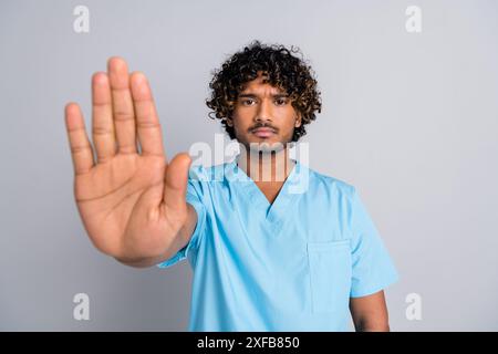 Foto von ernsthaftem Kerl Doktor halten Hand machen Stoppsymbol isolierten grauen Hintergrund Stockfoto