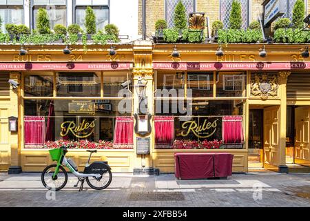 London, UK - 9. Mai 2024: Das Restaurant Rules mit einem Uber Lime Bike im Freien. Gegründet 1798 von Thomas Rule, gegründet 1798, serviert klassische Bri Stockfoto