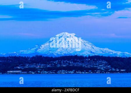 Violette und blaue Farbtöne nach Sonnenuntergang bilden ein wunderschönes Porträt des Mount Rainier im Bundesstaat Washington. Stockfoto