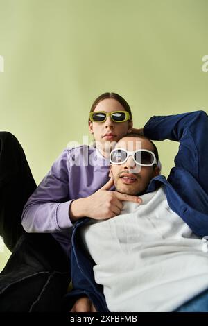 Zwei Männer sitzen zusammen, beide tragen eine Sonnenbrille. Stockfoto