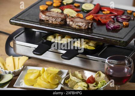 Schweizer Raclette mit Fleisch und Gemüse Stockfoto