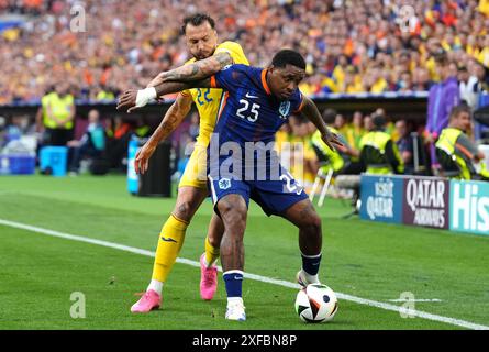 Der rumänische Vasile Mogos (links) und der niederländische Steven Bergwijn kämpfen um den Ball während der UEFA Euro 2024, einem Achtelfinale in der Münchner Fußball-Arena. Bilddatum: Dienstag, 2. Juli 2024. Stockfoto