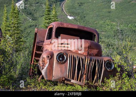 Ein alter, rostiger, alter Truck, eingebettet in die Wildnis mit Sommer-Bergkulisse. Stockfoto