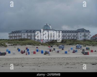 Ein großes Hotel am Strand mit zahlreichen bunten Liegen und bewölktem Himmel, Juist, Nordsee, deutschland Stockfoto