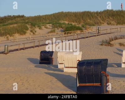 Mehrere Liegen in verschiedenen Farben auf einem Sandweg vor einer Düne, Juist, Nordsee, deutschland Stockfoto