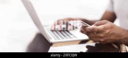 Tausendjährigen afrikanischen amerikanischen Mann mit Handy während der Arbeit Stockfoto