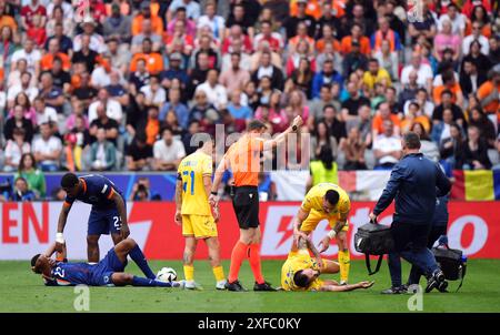 Der niederländische Denzel Dumfries und der rumänische Vasile Mogos wurden nach einer Kollision während der UEFA Euro 2024 behandelt, die im Achtelfinale in der Münchner Fußball-Arena stattfand. Bilddatum: Dienstag, 2. Juli 2024. Stockfoto