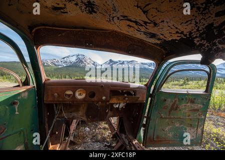 Ein alter, rostiger, alter Truck, eingebettet in die Wildnis mit Sommer-Bergkulisse. Aufgenommen auf der North Canol Road im Norden Kanadas Stockfoto