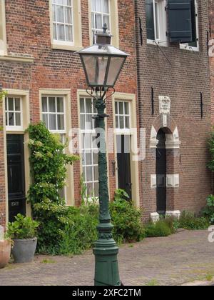 Vintage Straßenlaterne vor einem historischen Backsteingebäude in Leiden, Niederlande Stockfoto