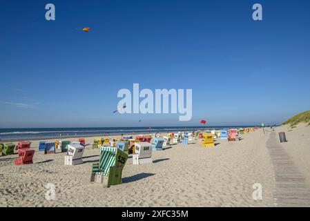 Bunte Liegen und Drachen an einem sonnigen Strand mit blauem Himmel und Meer, langeoog, ostfriesland, deutschland Stockfoto