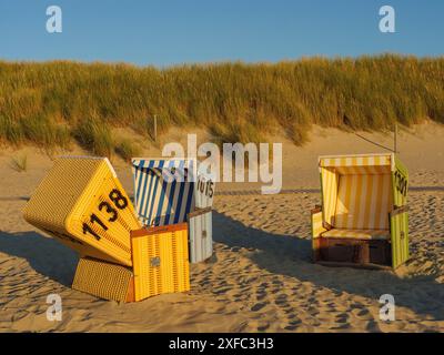 Drei bunte Liegen am Strand neben den Dünen im Sonnenlicht, langeoog, ostfriesland, deutschland Stockfoto