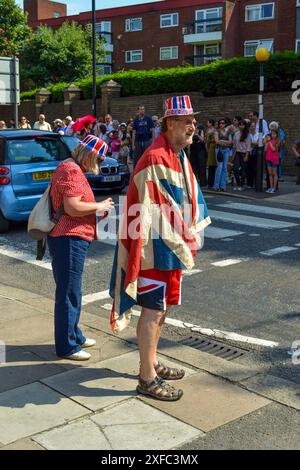 Southgate, London, Großbritannien - 25. Juli 2012: Patriotischer Mann mit Union Jack Hut und Shorts, die bei der Olympischen Fackelparade 2012 mit der Flagge von Union Jack bedeckt sind Stockfoto