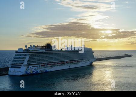 Civitavecchia, Italien - 22. Mai 2024: Norwegisches Kreuzfahrtschiff Norwegian Escape dockt am Passagierterminal an, Kreuzfahrtschiff bei Sonnenuntergang Stockfoto