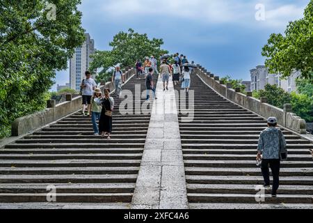 Ein Foto zeigt die Gongchen-Brücke, die höchste und längste Steinbogenbrücke über den Peking-Hangzhou Grand Canal, ein Wahrzeichen am südlichen Ende des Kanals und das Weltkulturerbe des Grand Canal, am 18. Juni 2024 in Hangzhou, China. Mit einer Länge von 98 Metern und einer Höhe von 16 Metern ist die Gongchenbrücke in der Mitte des Brückenbodens 5,9 Meter breit und am Ende der Brücke 12,2 Meter breit. Sie ist die höchste und längste Steinbogenbrücke zwischen alten Brücken in Hangzhou und ein Wahrzeichen am südlichen Ende des Canal Grande. (Foto: Costfoto/ Stockfoto