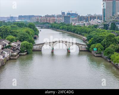 Ein Foto zeigt die Gongchen-Brücke, die höchste und längste Steinbogenbrücke über den Peking-Hangzhou Grand Canal, ein Wahrzeichen am südlichen Ende des Kanals und das Weltkulturerbe des Grand Canal, am 18. Juni 2024 in Hangzhou, China. Mit einer Länge von 98 Metern und einer Höhe von 16 Metern ist die Gongchenbrücke in der Mitte des Brückenbodens 5,9 Meter breit und am Ende der Brücke 12,2 Meter breit. Sie ist die höchste und längste Steinbogenbrücke zwischen alten Brücken in Hangzhou und ein Wahrzeichen am südlichen Ende des Canal Grande. (Foto: Costfoto/ Stockfoto