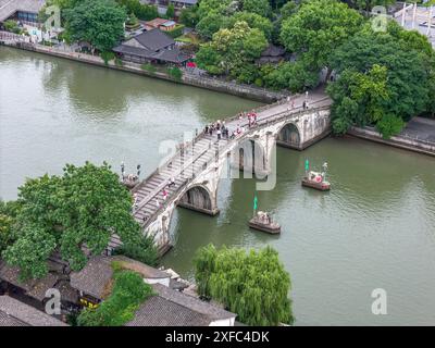 Ein Foto zeigt die Gongchen-Brücke, die höchste und längste Steinbogenbrücke über den Peking-Hangzhou Grand Canal, ein Wahrzeichen am südlichen Ende des Kanals und das Weltkulturerbe des Grand Canal, am 18. Juni 2024 in Hangzhou, China. Mit einer Länge von 98 Metern und einer Höhe von 16 Metern ist die Gongchenbrücke in der Mitte des Brückenbodens 5,9 Meter breit und am Ende der Brücke 12,2 Meter breit. Sie ist die höchste und längste Steinbogenbrücke zwischen alten Brücken in Hangzhou und ein Wahrzeichen am südlichen Ende des Canal Grande. (Foto: Costfoto/ Stockfoto