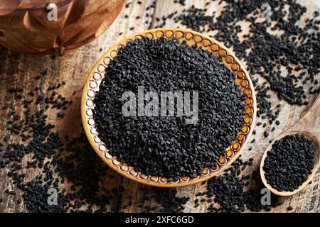 Schwarzkümmel oder Nigella sativa Samen in einer Holzschale, Blick von oben. Gesunde Nahrungsergänzung. Stockfoto