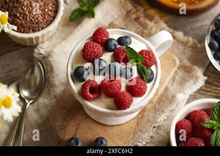 Hüttenkäse gemischt mit Leinöl, belegt mit frischen Heidelbeeren und Himbeeren Stockfoto