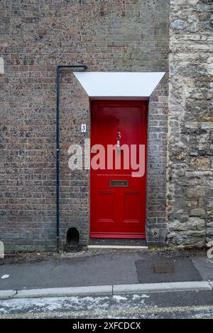 Rote Tür, Backsteingebäude. Dorchester, Großbritannien Stockfoto